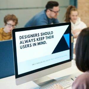 Group of designers collaborating in modern office space with computer.
